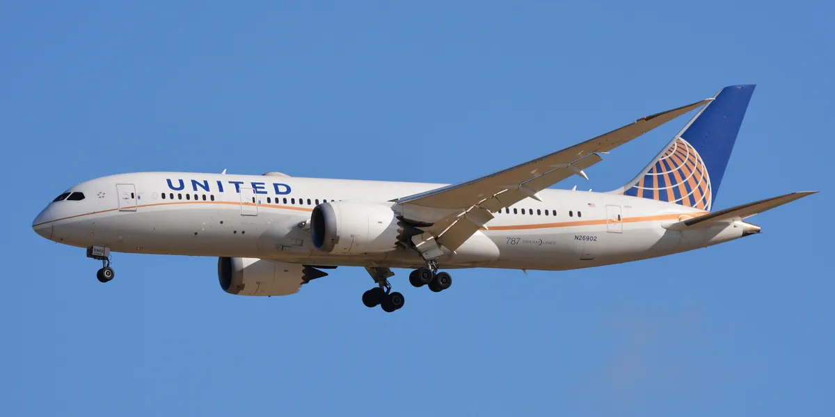 United Airlines Boeing 787-8 N26902 climbing against a clear blue sky, three-quarter view showing its stubby body, raked wingtips, and saw-tooth-edged engine pods.