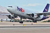 FedEx Express Airbus A300-600F freighter lifting off, three-quarter view showing its underwing engines and purple tail livery.