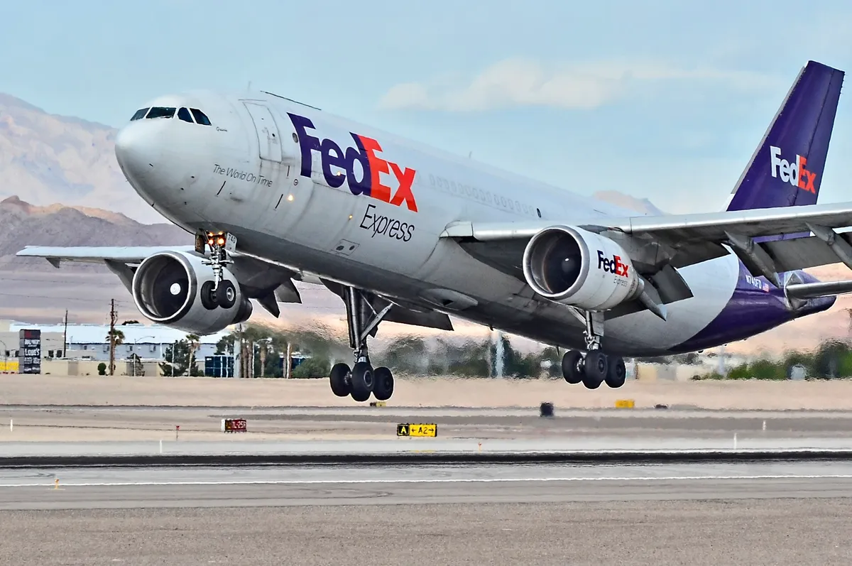 FedEx Express Airbus A300-600F freighter lifting off, three-quarter view showing its underwing engines and purple tail livery.