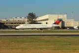 Delta Air Lines Boeing 717-200 taxiing in golden-hour light, side profile showing its T-tail and short, stubby body.