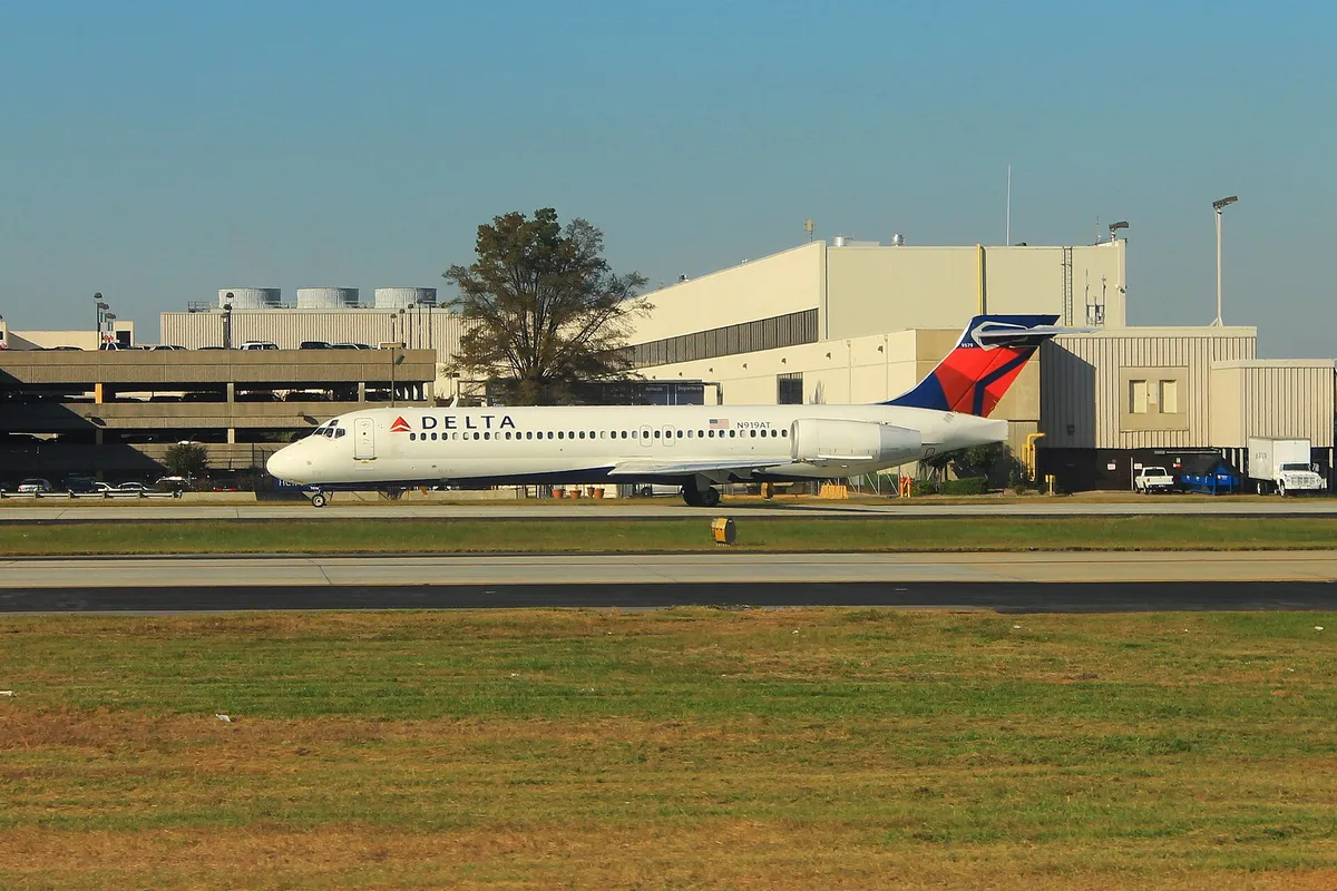 Delta Air Lines Boeing 717-200 taxiing in golden-hour light, side profile showing its T-tail and short, stubby body.
