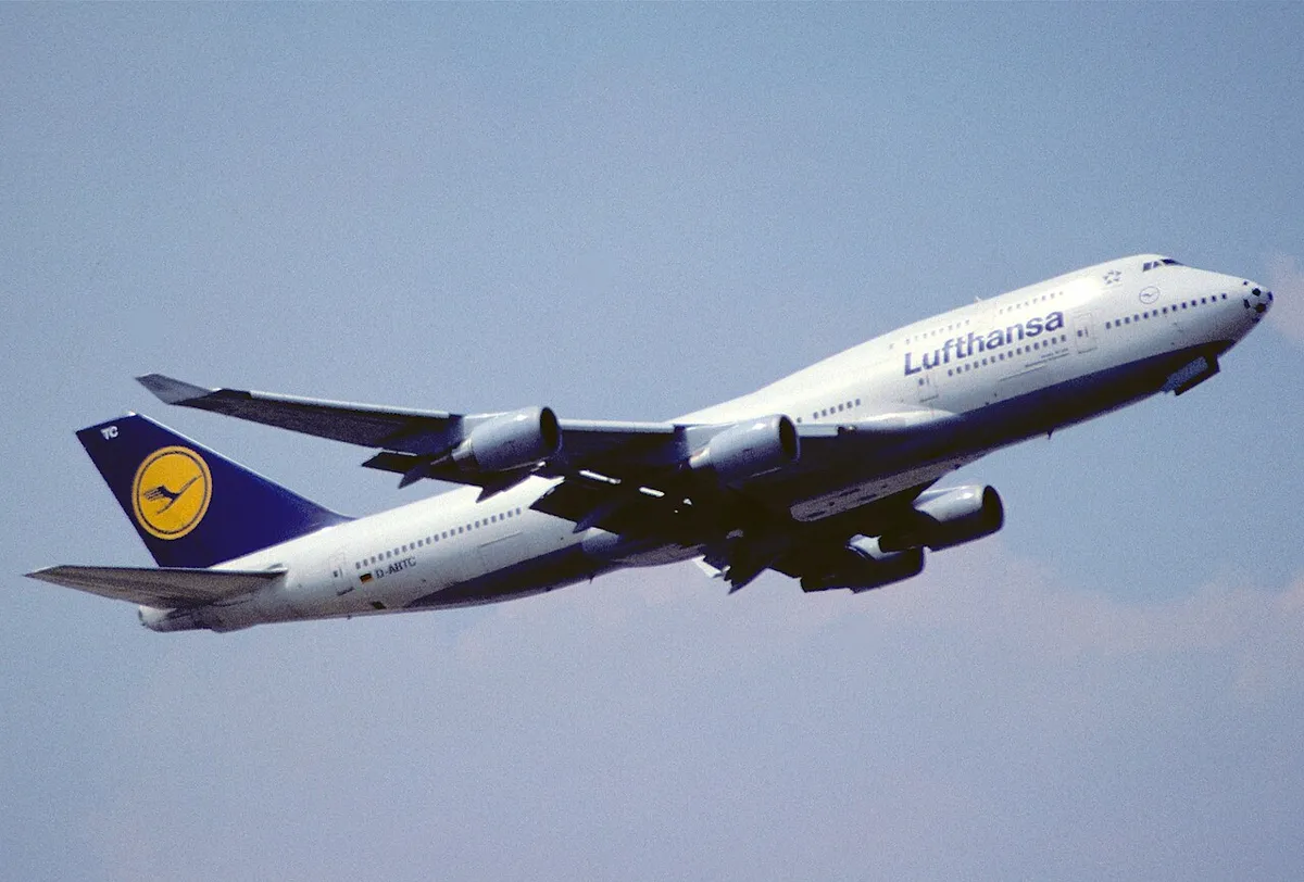 Lufthansa Boeing 747-430 climbing away from Frankfurt Airport in three-quarter view, showing its upturned wingtip blade and front hump with a second row of windows.