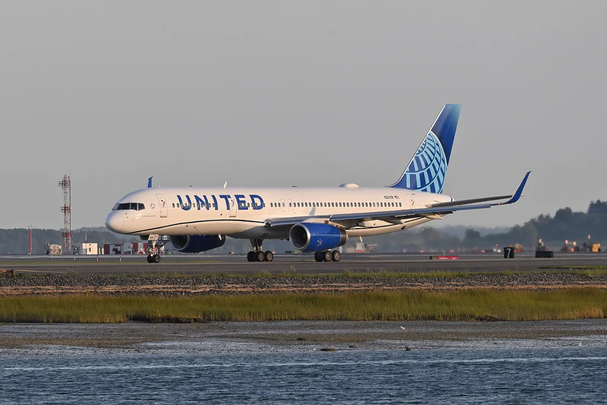 United Airlines Boeing 757-200 taxiing at Boston, three-quarter rear view showing its long slender body and four-wheel main landing gear legs.
