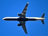 JetBlue Airbus A321-271NX seen directly from below against a clear blue sky, showing the underside outline, upturned wingtip blades, and oversized LEAP-1A engine pods.