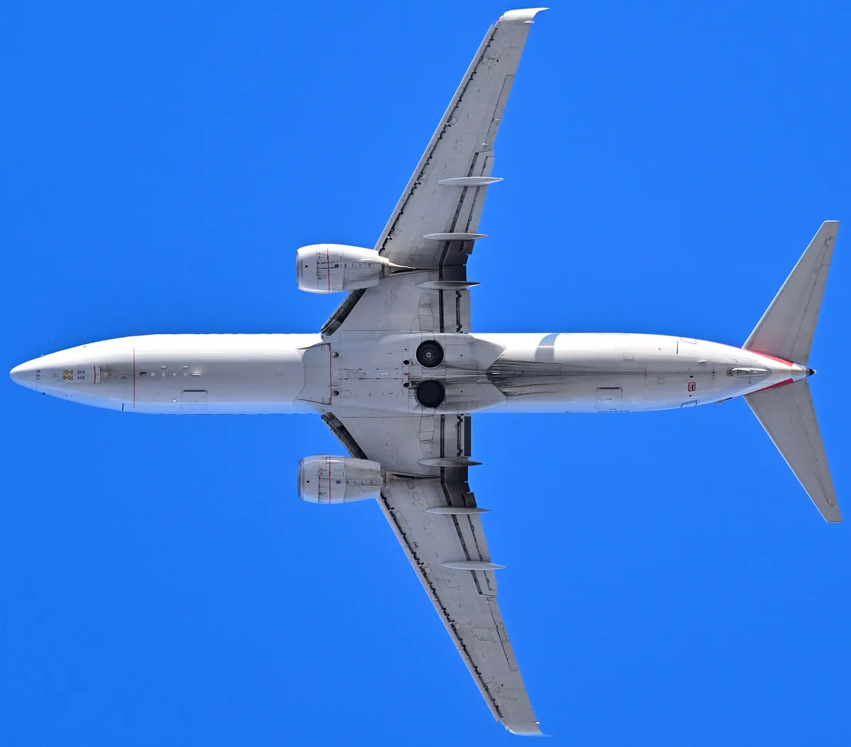 American Airlines Boeing 737-800 seen directly from below departing Boston, showing the underside outline and engine pods.