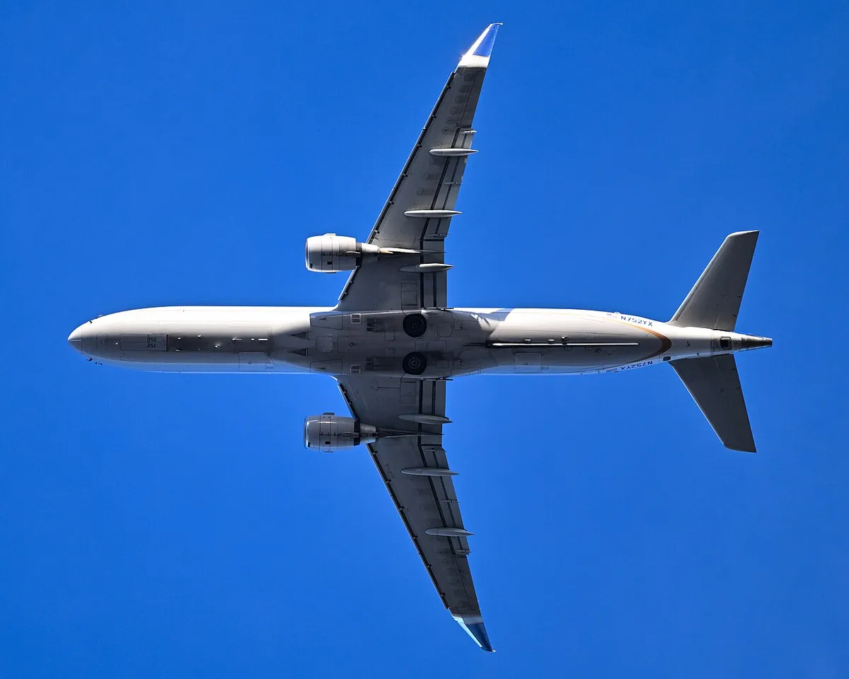 United Express Embraer E175 seen directly from below on departure, showing the underwing engines and enhanced wingtip blades.
