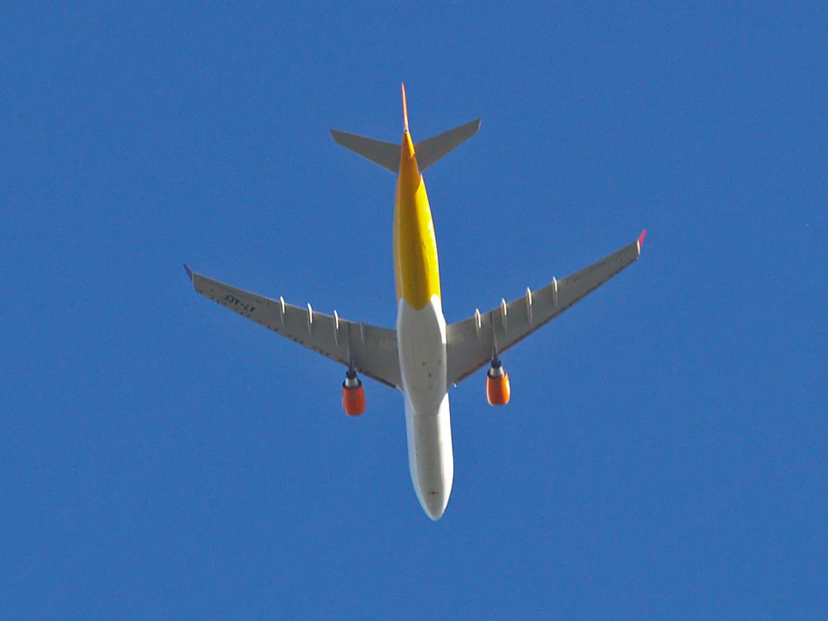 Qatar Airways Airbus A330-300 seen directly from below, showing the underside outline, engine pods, and upturned wingtip blades.