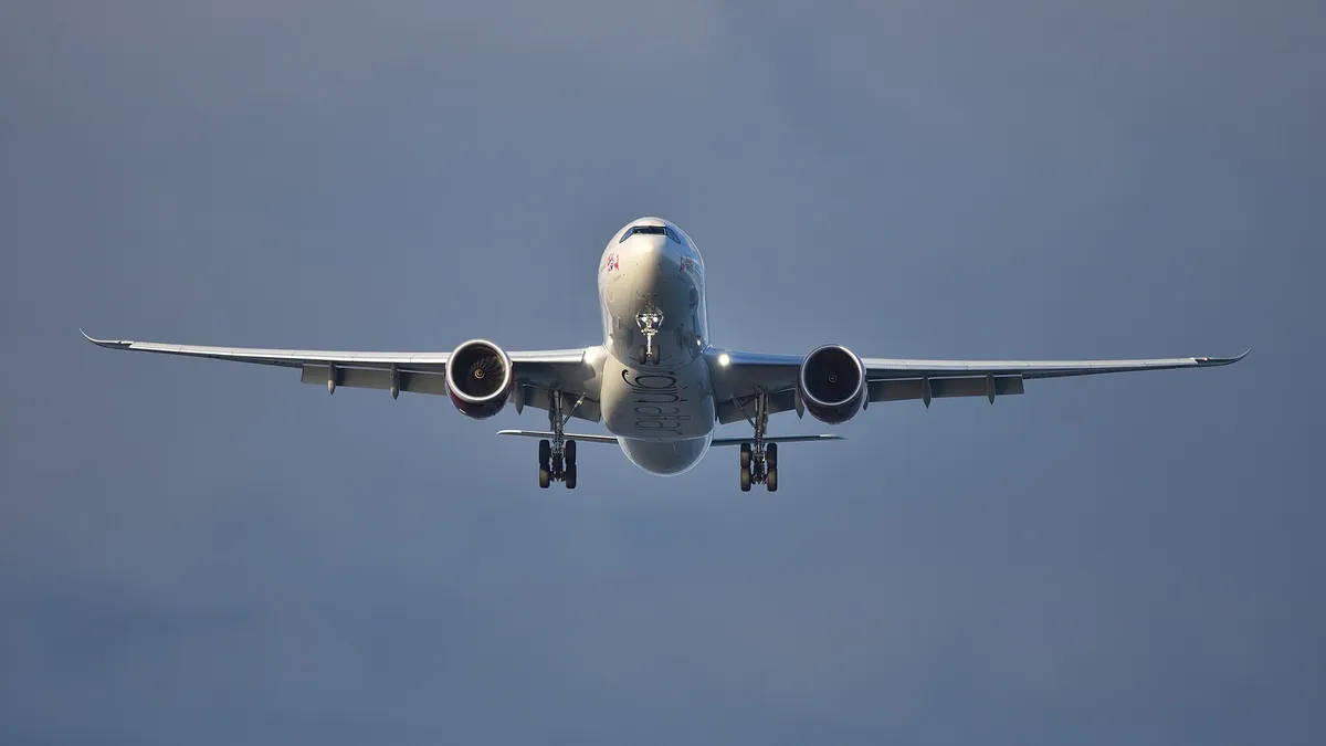 Virgin Atlantic Airbus A330-900neo seen head-on from below on final approach, showing the belly, oversized engine pods, and wing shape.