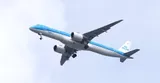 KLM Cityhopper Embraer E195-E2 PH-NXM climbing directly overhead with gear down, showing the underside outline, large engine pods, and swept wing.
